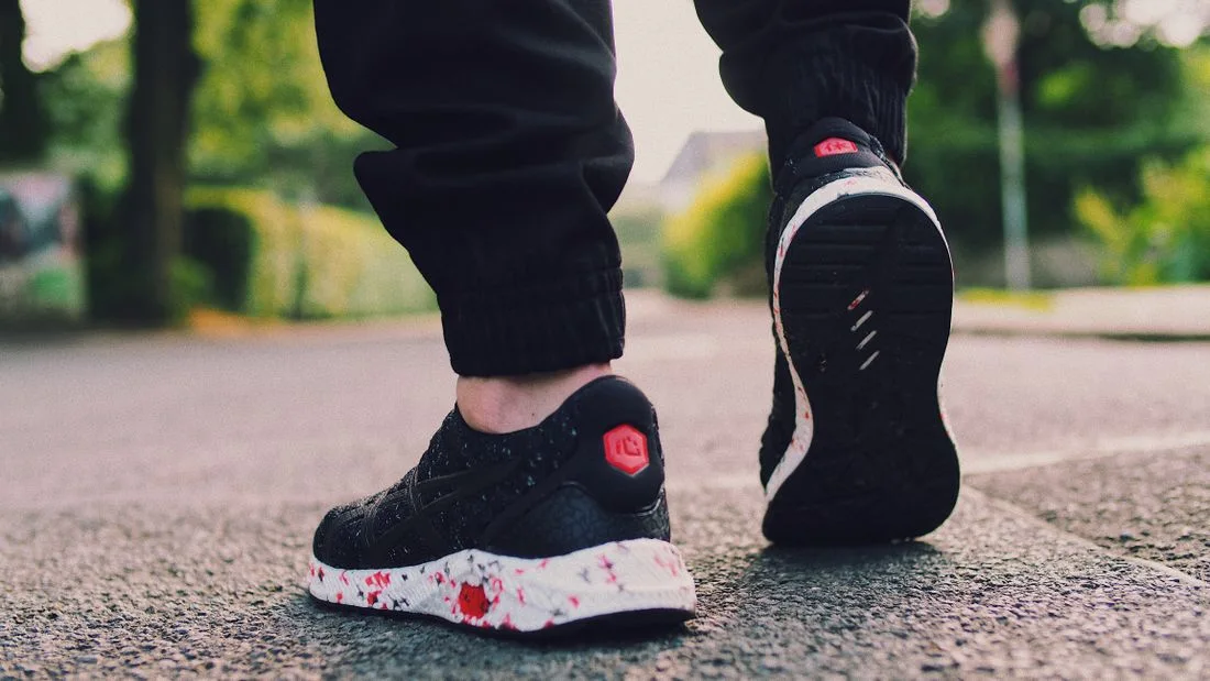 Close-up of sneakers walking along a street